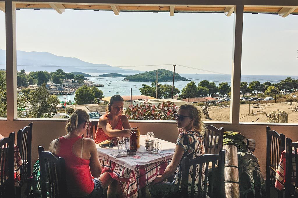 3 osoby przy stole w knajpce w ksamil