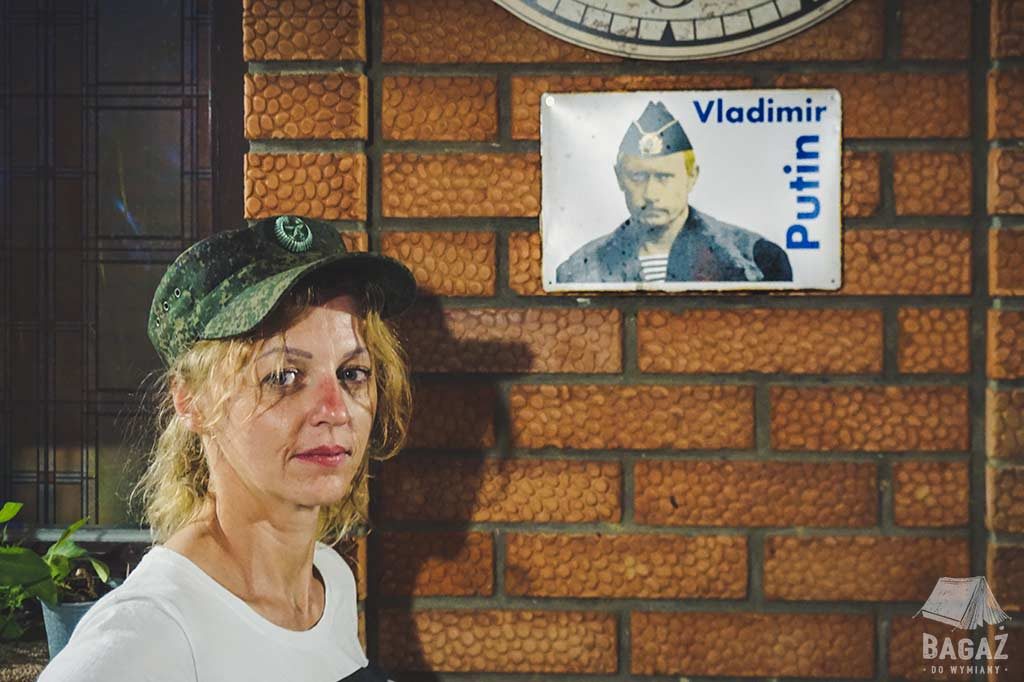 kobieta w wojskowej czapce na tle ściany z podobizna vladimira putina tyraspol